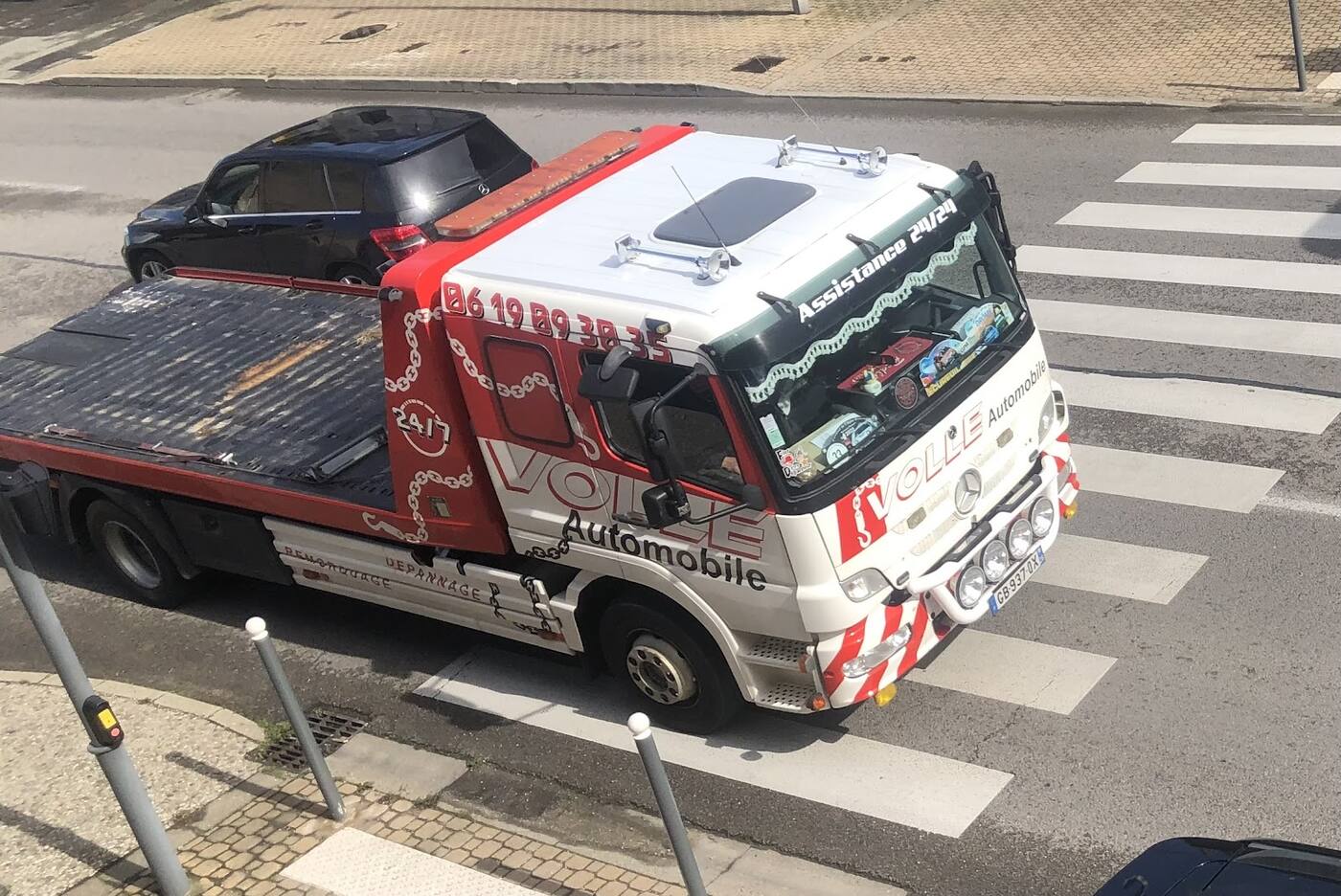 La dépanneuse Volle Automobile vue d'en haut, plateau vide, à un passage piéton en ville